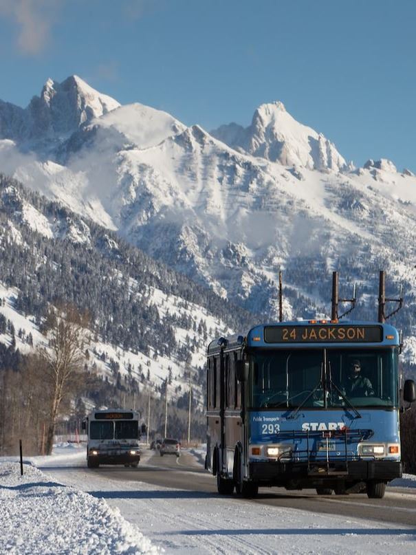 START buses driving on 22 in Winter with Tetons in background
