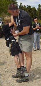 A police officer putting a harness on a child.